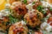 Juicy Greek chicken meatballs with fresh tzatziki sauce served on a white plate