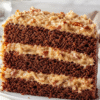 Sliced delicious German chocolate cake with coconut pecan frosting on a cake stand