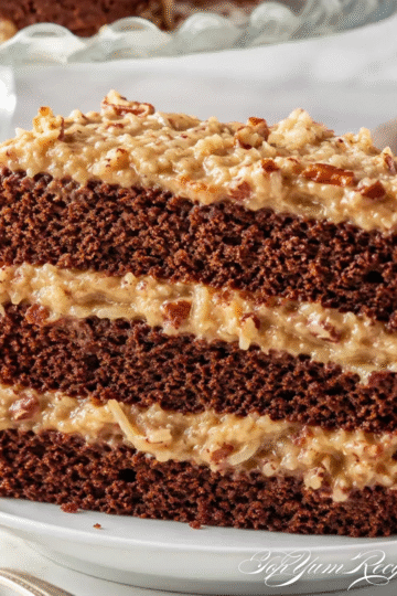 Sliced delicious German chocolate cake with coconut pecan frosting on a cake stand