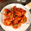Alt text: "Close-up of crispy Korean fried chicken wings with a glossy, golden double-fried crust